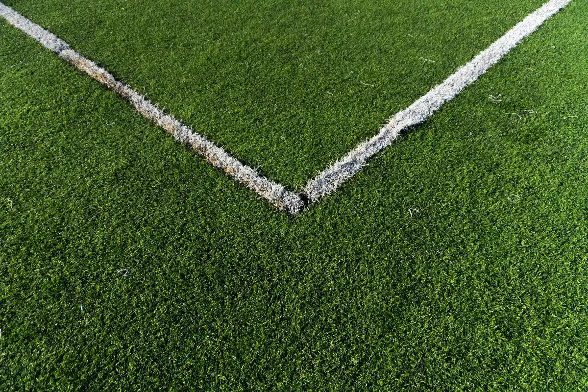 Instalación de rollos de césped artificial en un campo de fútbol municipal