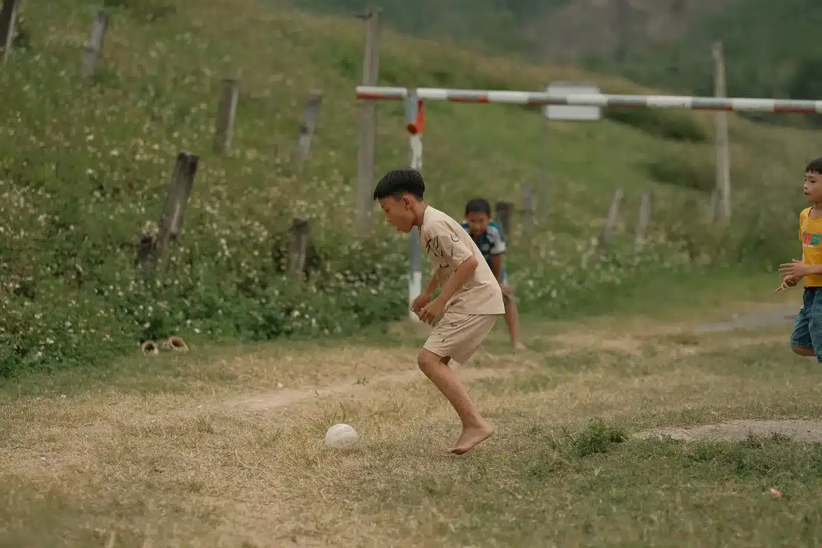 Niños entrenando en un campo de fútbol con superficie de césped artificial seguro