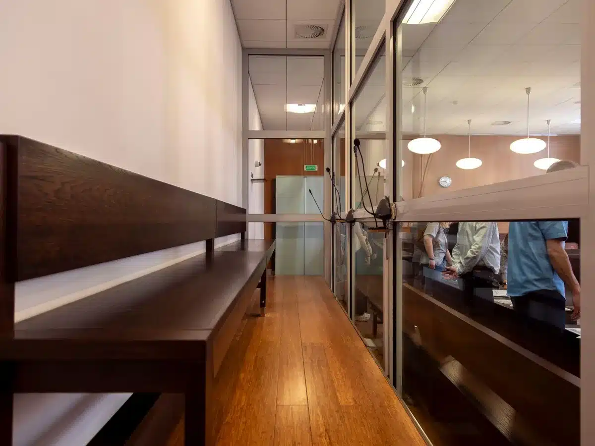 Sala de tribunal con bancos de madera y escudo de justicia