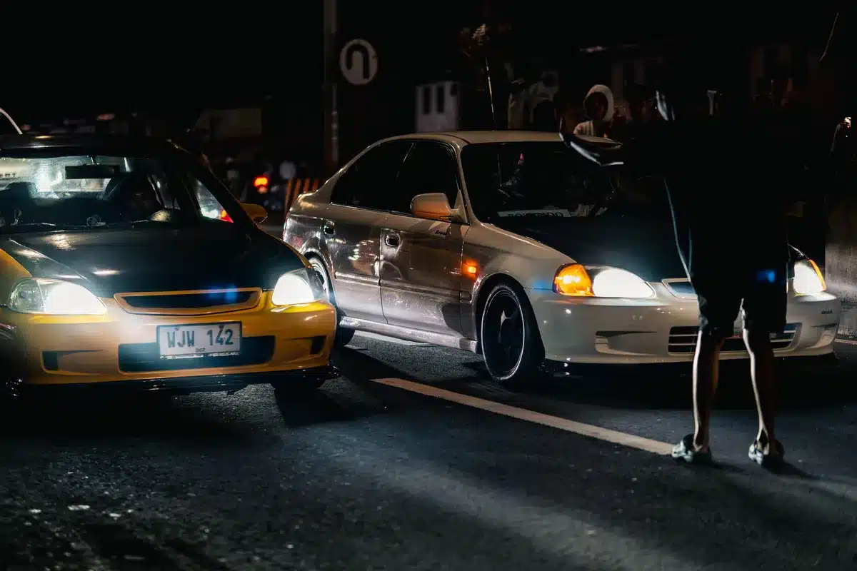 Carreras callejeras ilegales con autos tuneados en ambiente urbano nocturno