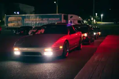 Autos de carreras en calles urbanas nocturnas con luces de neón y movimiento de velocidad