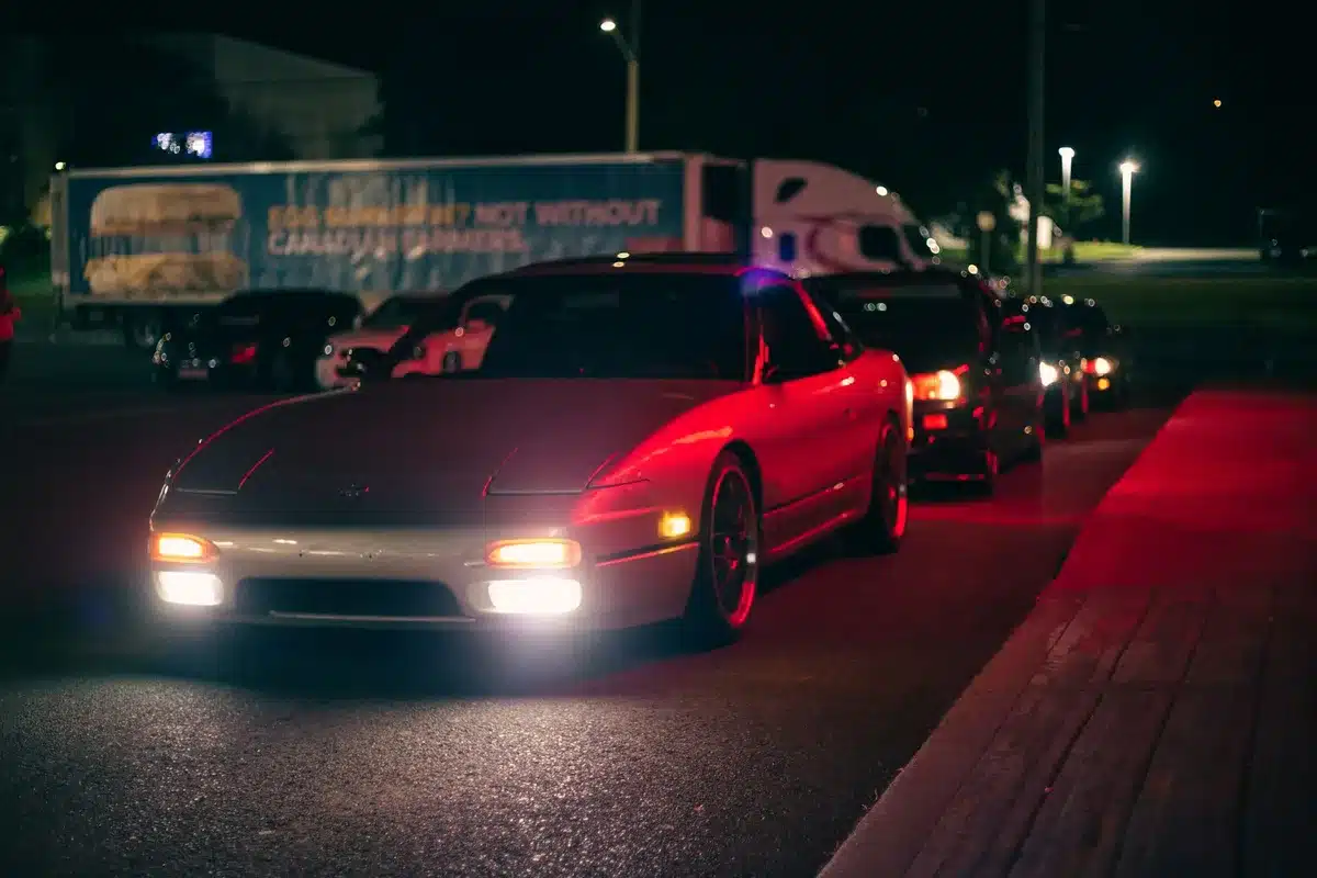 Autos de carreras en calles urbanas nocturnas con luces de neón y movimiento de velocidad