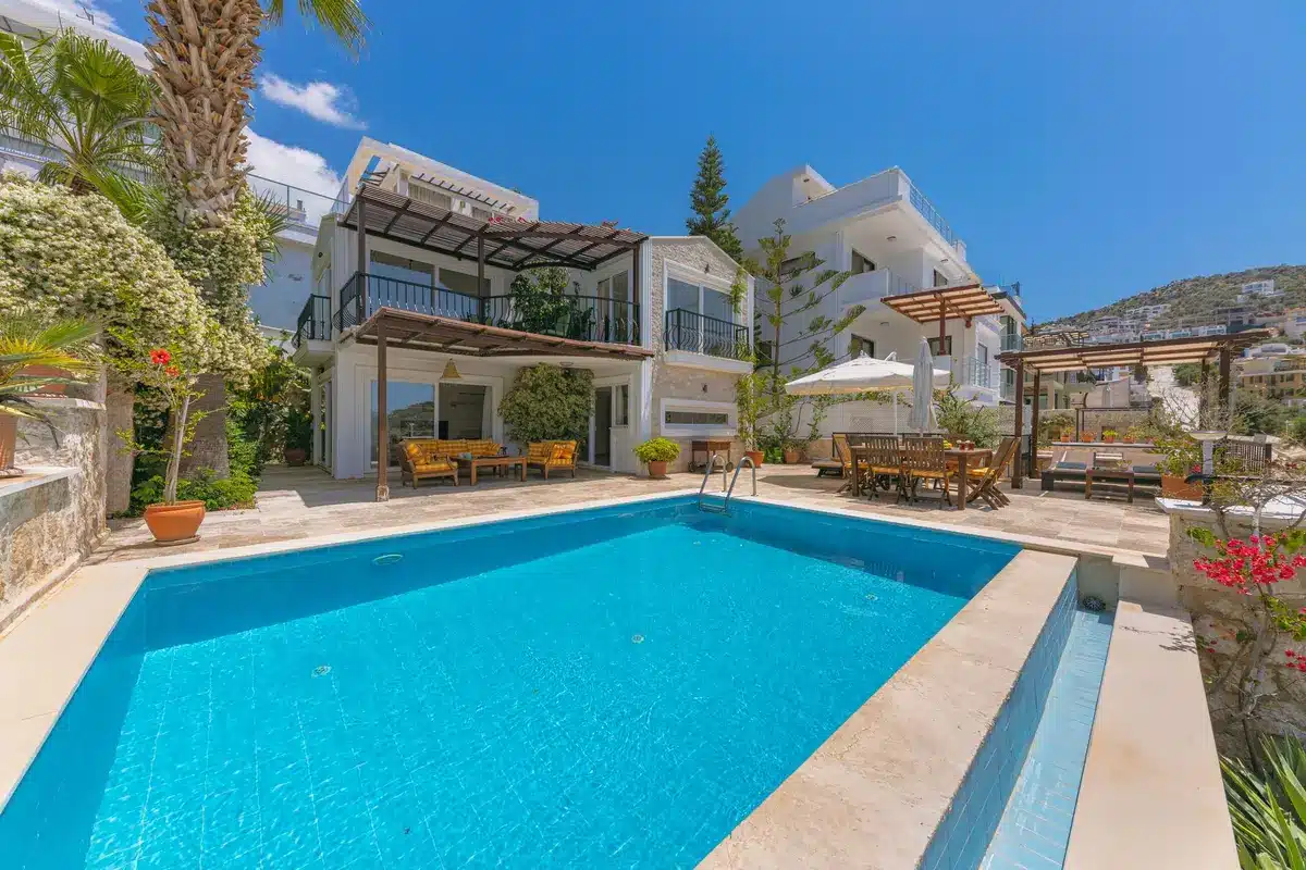 Casa de estilo mediterráneo con jardines privados y piscina rodeada de vegetación