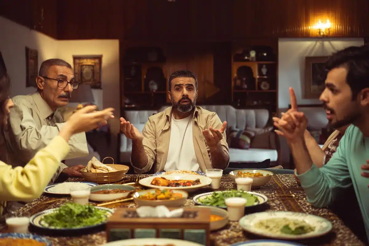 Familia reunida alrededor de una mesa compartiendo una comida, expresiones de calidez y conversación íntima.