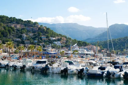 Pueblo de pescadores con casas blancas, barcas en la orilla y pinar junto al Mediterráneo