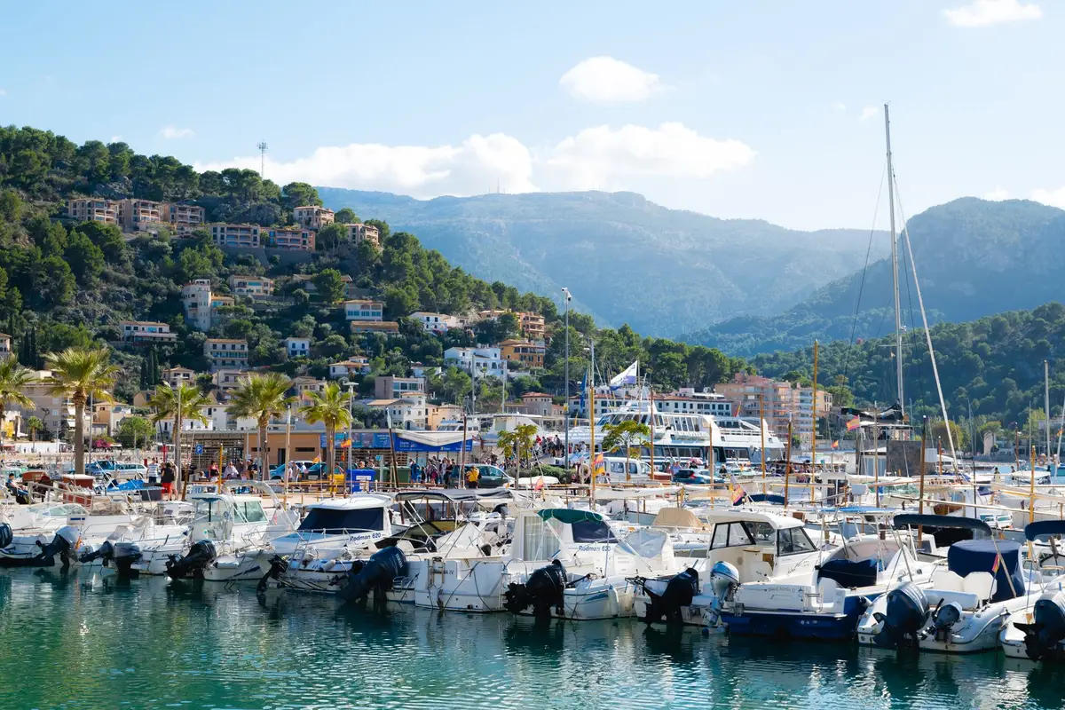 Pueblo de pescadores con casas blancas, barcas en la orilla y pinar junto al Mediterráneo