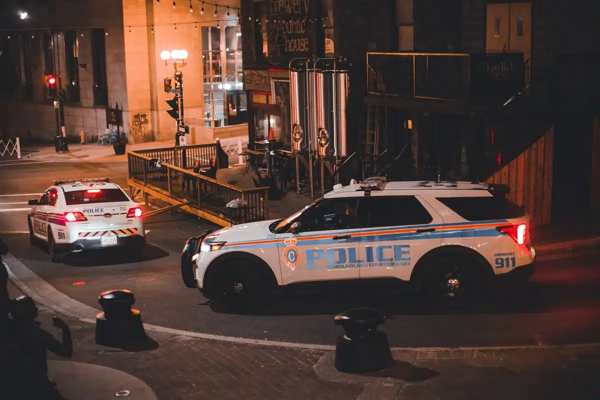 Vehículo de patrulla policial circulando por una calle durante operativo nocturno de seguridad