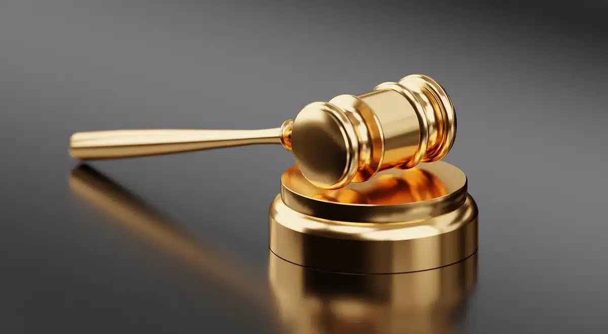 Martillo de juez y expedientes sobre una mesa en sala de justicia