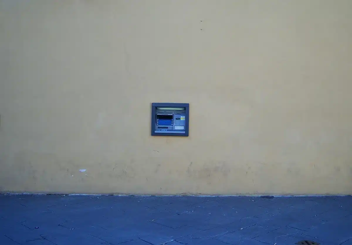 A generic close-up of an unbranded contactless credit card resting on a counter with a smartphone nearby, both anonymous and without logos