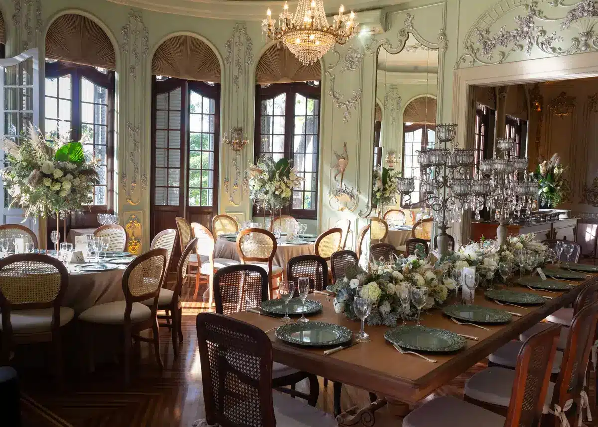 Empty grand reception hall with long banquet table set for a formal state dinner, chandeliers and place settings, no people