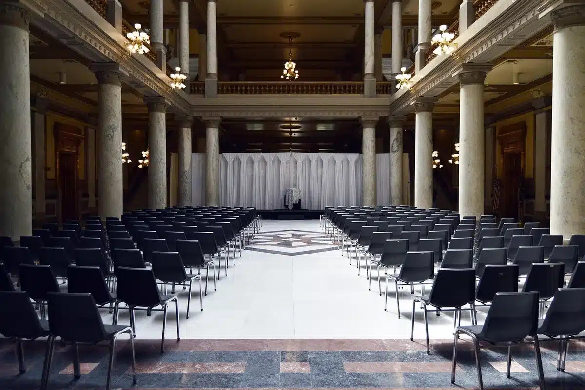 Empty conference hall with arranged chairs and a plain podium ready for a provincial party congress, no people, neutral lighting