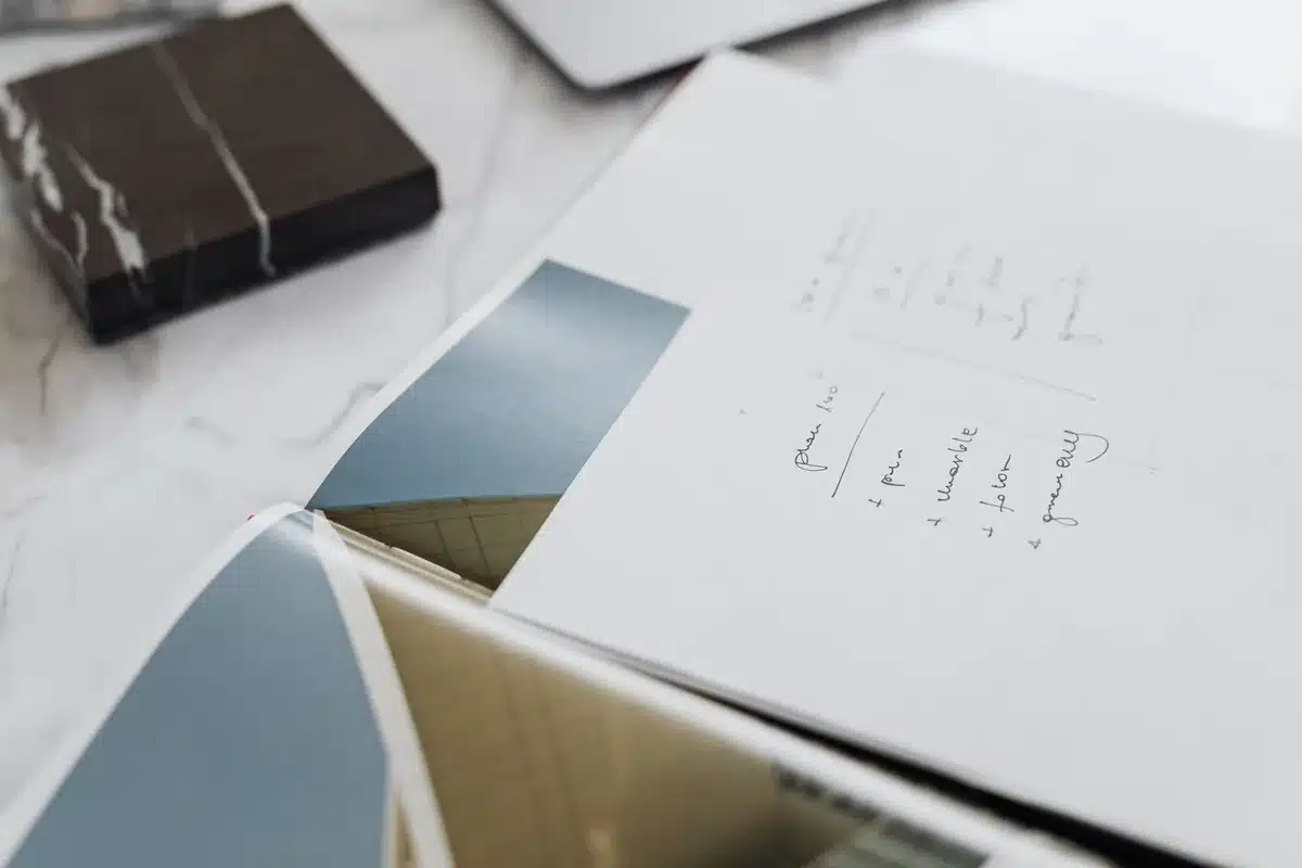 Anonymous close-up of architectural plans and hands pointing at annotated blueprints on a table, no identifiable people or logos