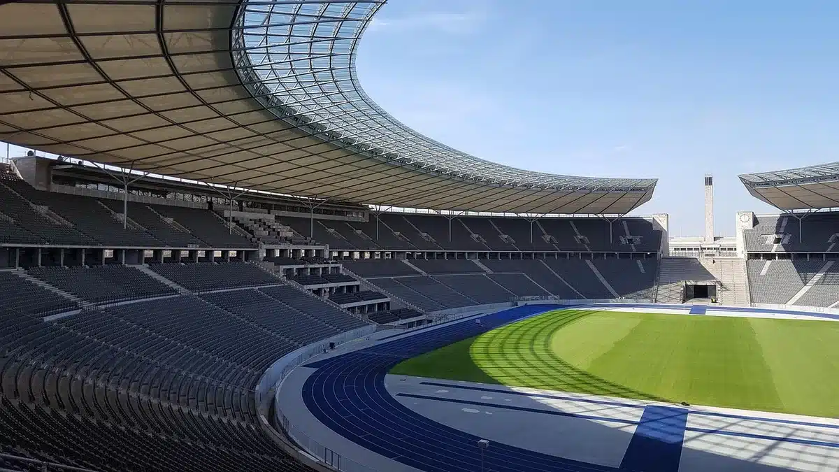 empty stadium stands under daylight, goalposts and seats visible, no people