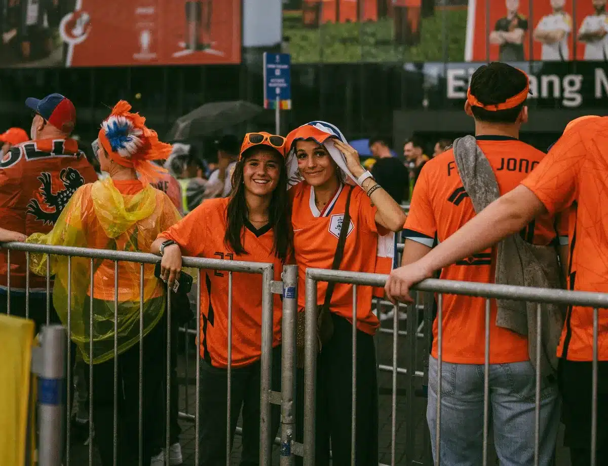 anonymous fans arriving outside a football stadium, scarves blurred, city entrance scene