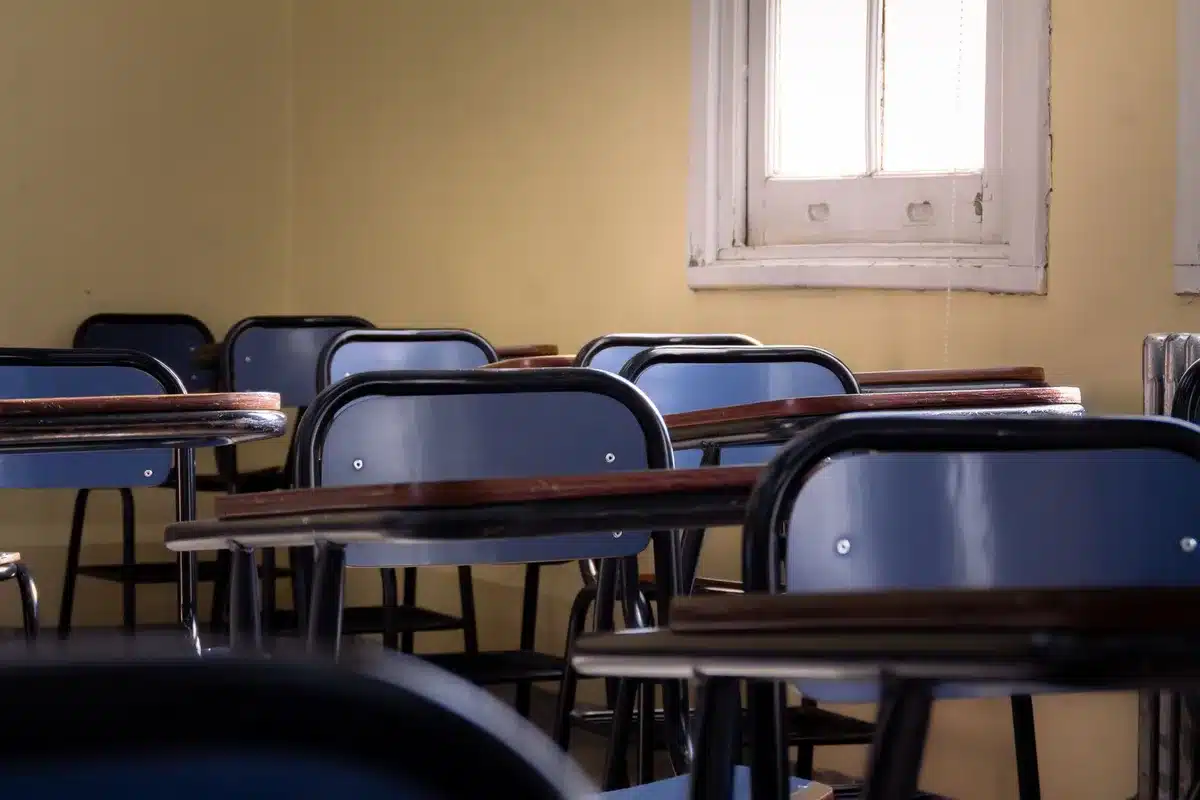Exterior view of a quiet empty classroom with desks and an unbranded globe on a shelf