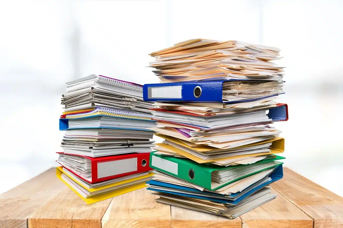 Documentación y formularios sobre una mesa representando trámites administrativos