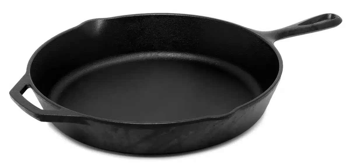 An empty kitchen counter with a stack of anonymous non-branded frying pans and a folded price tag card nearby, soft natural light, inviting still-life