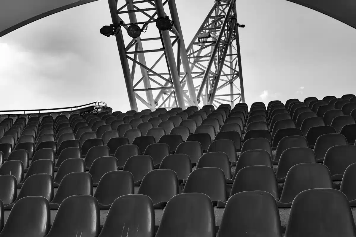 Empty stadium seats with a rolled-up team scarf on a seat, goalposts in the background