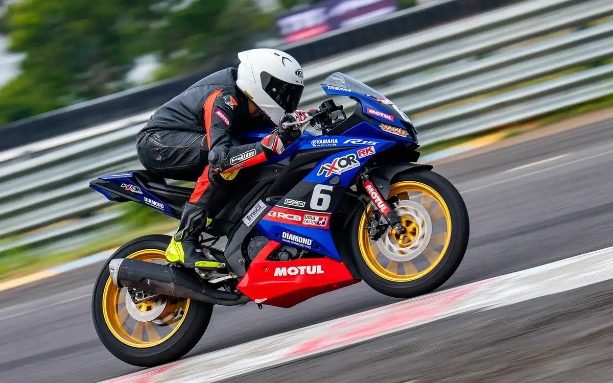 A dynamic shot of an anonymous motorbike in motion on a deserted circuit at dusk; dust and motion blur emphasise speed, no faces or logos visible
