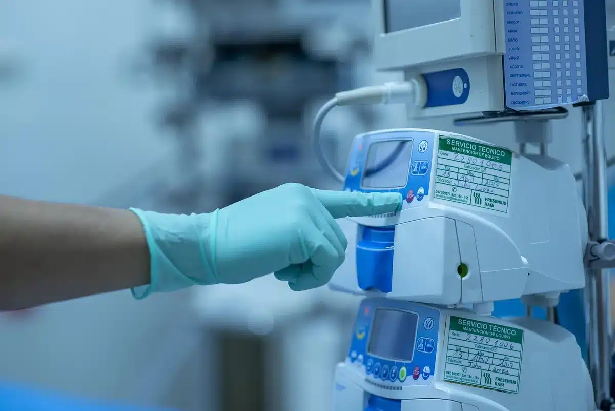 Manos con guantes y un bisturí sobre una mesa de quirófano, ambiente hospitalario