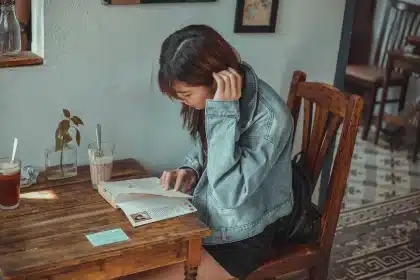 Silhouette de una persona leyendo un guion con un libro de frases y café sobre la mesa
