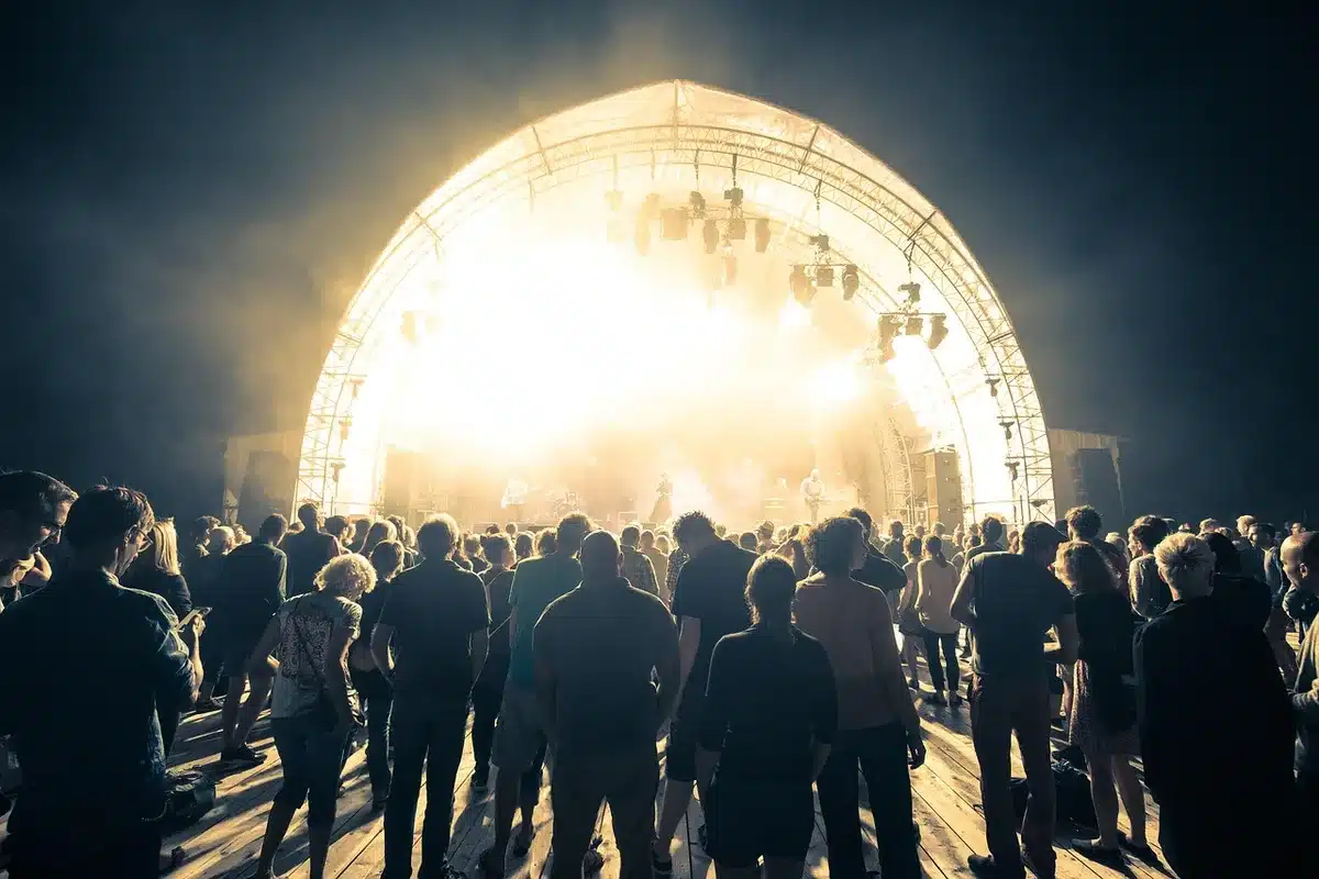 Personas conversando entre conciertos en un festival con vasos de cerveza
