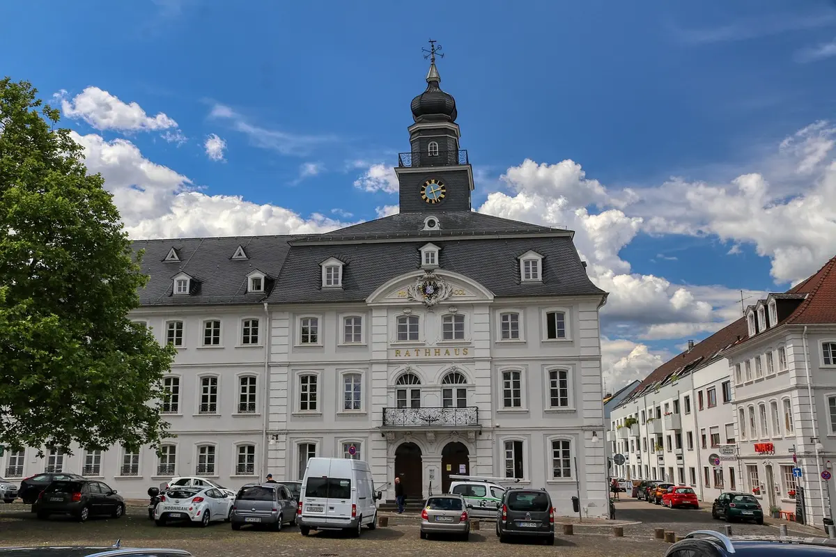 Empty city hall exterior with flags and an empty reception area suggesting an upcoming official visit
