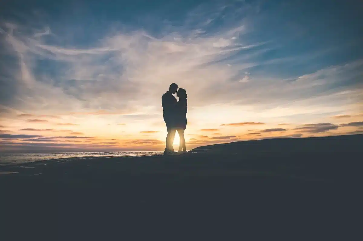 Anonymous couple photographed in evening attire walking past photographers, faces blurred and unidentifiable