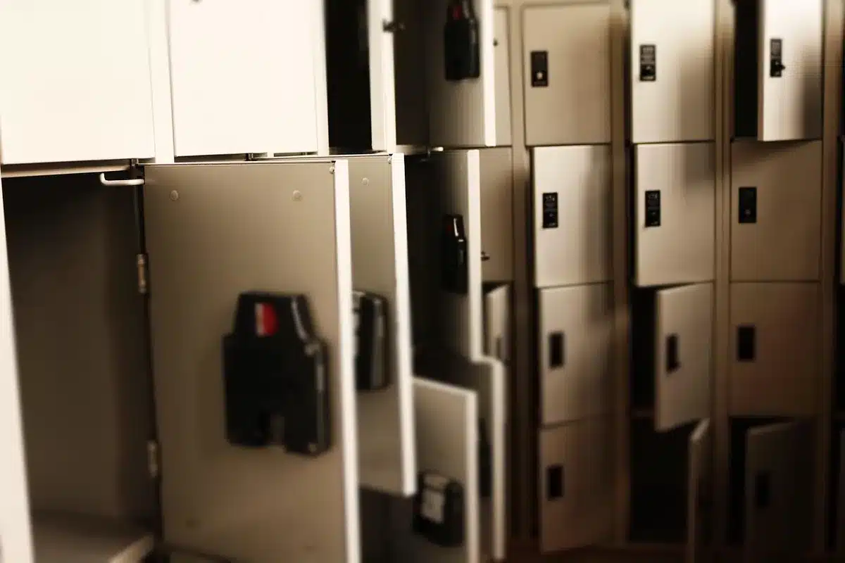 Empty locker room with a single pair of boots on the bench, stadium seats blurred beyond