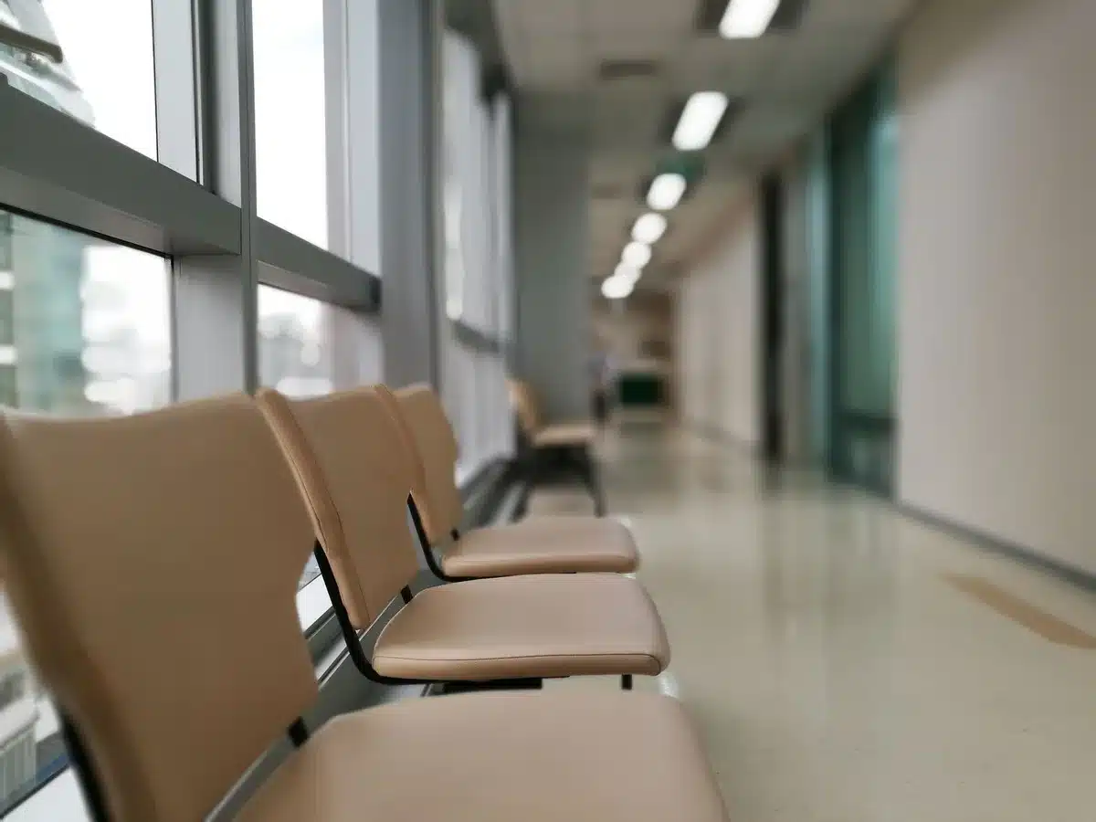 An empty hospital corridor with a single nurse's chair under soft light, a folded uniform on the seat, no logos or identifiable people