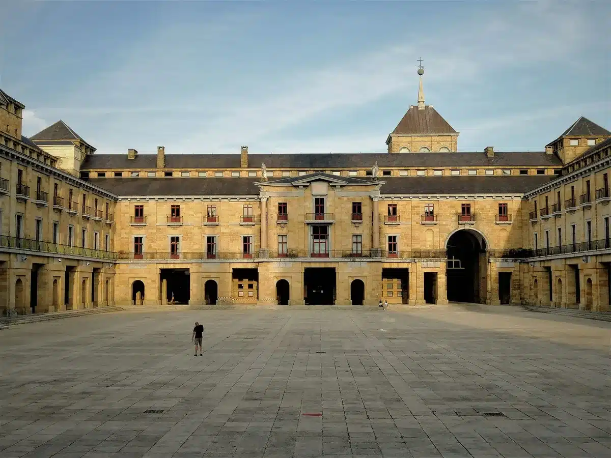 Interior courtyard of a municipal building with empty chairs and a flagpole visible, soft daylight, no people