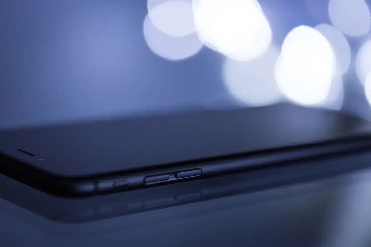 Close-up of an anonymous hand holding an unbranded smartphone showing a bright, abstract screen glow, no logos visible