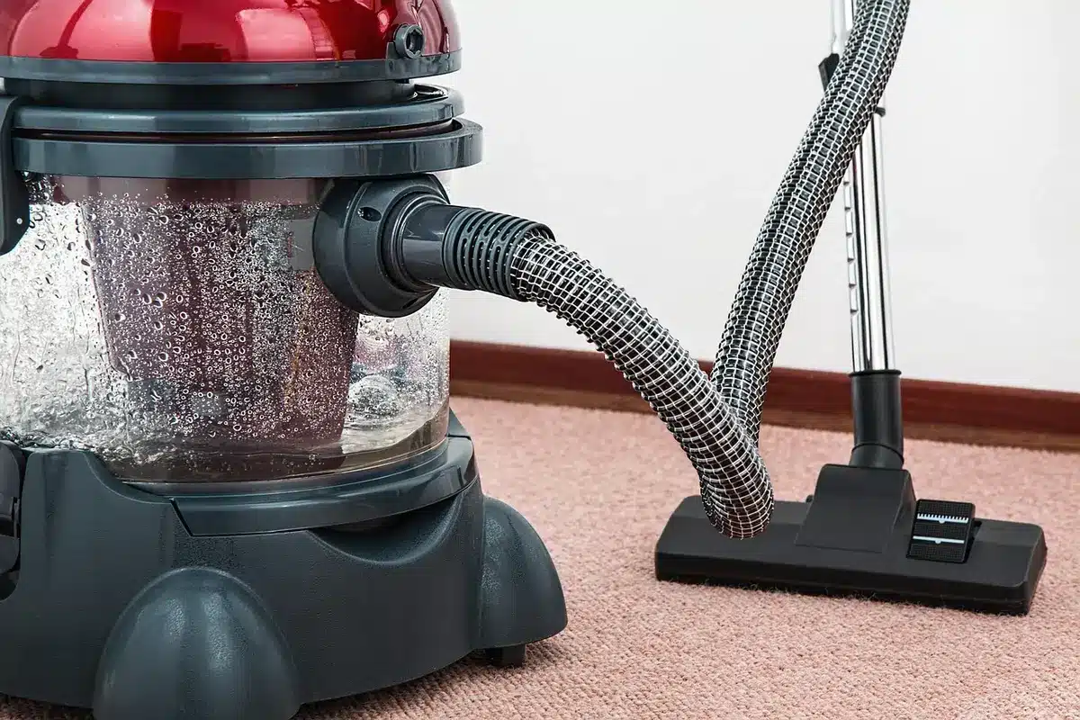 Close-up of the vacuum's removable battery pack and LED motor head on a hardwood floor, no logos or text visible