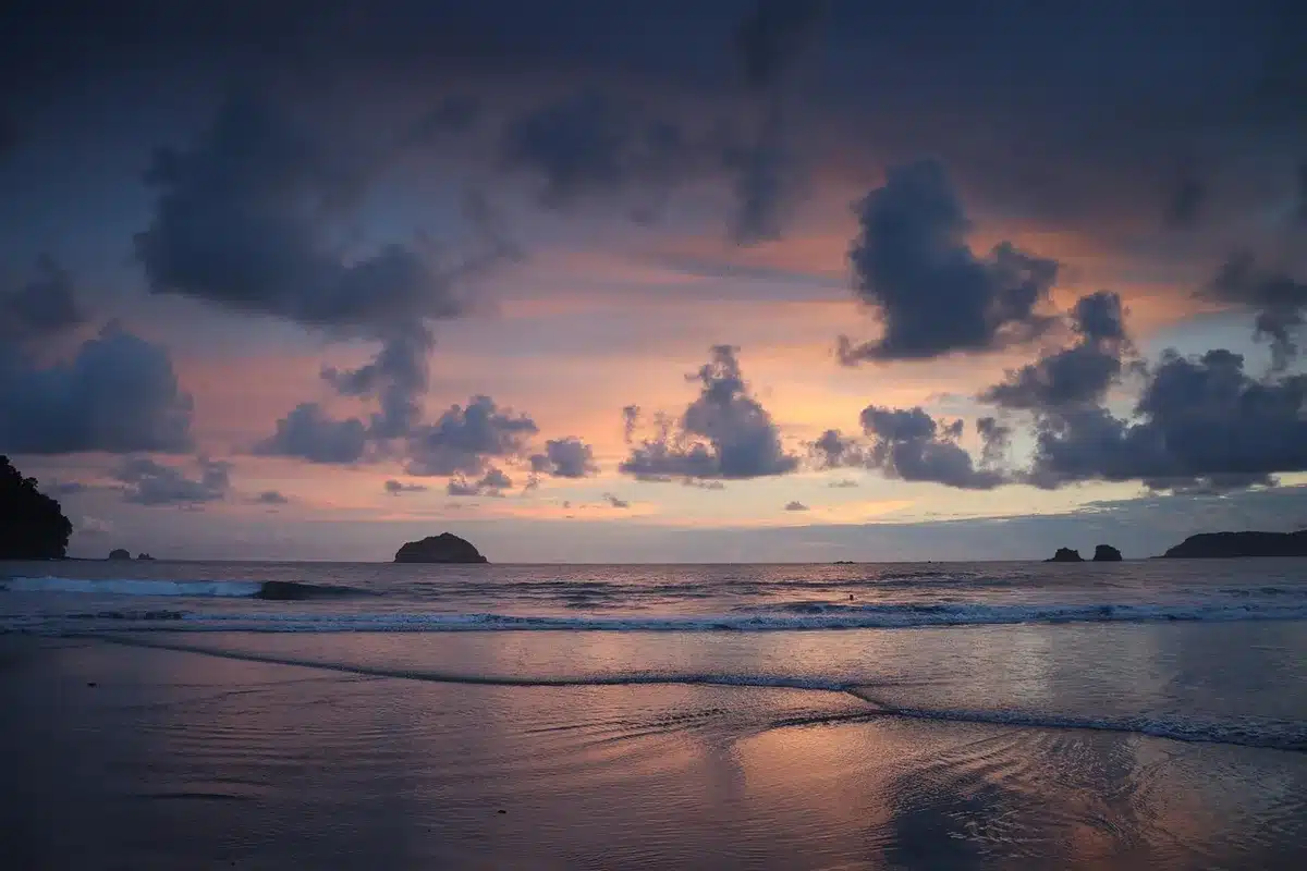aerial shot of an empty tropical beach with a simple wooden bench and a small unbranded camera rig, evoking the show's island setting