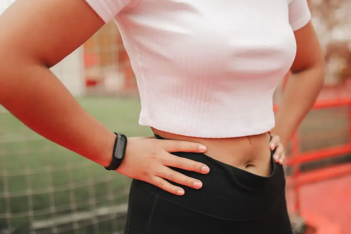 close-up of an unbranded sleek fitness band on a neutral surface, display lit showing simple icons