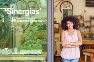Young mixed race woman smiling while standing in the door of her cafe with her arms folded proud to be the owner of a small business